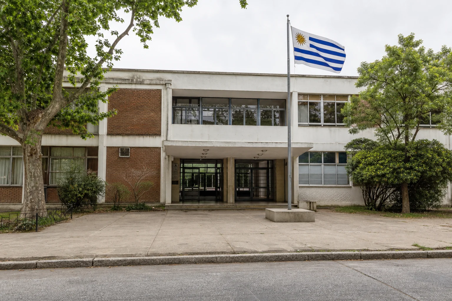 Exterior de un centro educativo de Uruguay con la bandera nacional visible junto a la entrada
